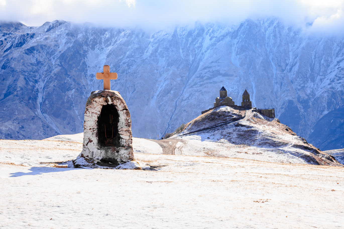 Gergeti Trinity Church or Tsminda Sameba Church with cross is on the mt. kazbek near the town of Stepantsminda in Georgia.